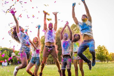 Holi ile oynarken mutlu arkadaş grubu bir parkta - Genç Yetişkin eğlenceli, eğlenceli ve genç nesil hakkındaki kavramları bir holi Festivali, eğleniyor renkler.