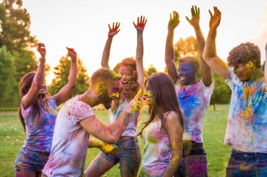 Holi ile oynarken mutlu arkadaş grubu bir parkta - Genç Yetişkin eğlenceli, eğlenceli ve genç nesil hakkındaki kavramları bir holi Festivali, eğleniyor renkler.