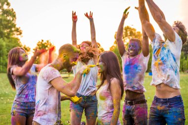 Holi ile oynarken mutlu arkadaş grubu bir parkta - Genç Yetişkin eğlenceli, eğlenceli ve genç nesil hakkındaki kavramları bir holi Festivali, eğleniyor renkler.