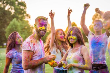 Holi ile oynarken mutlu arkadaş grubu bir parkta - Genç Yetişkin eğlenceli, eğlenceli ve genç nesil hakkındaki kavramları bir holi Festivali, eğleniyor renkler.