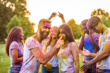 Holi ile oynarken mutlu arkadaş grubu bir parkta - Genç Yetişkin eğlenceli, eğlenceli ve genç nesil hakkındaki kavramları bir holi Festivali, eğleniyor renkler.