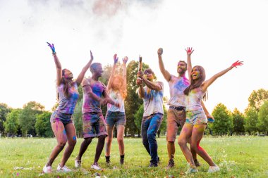 Holi ile oynarken mutlu arkadaş grubu bir parkta - Genç Yetişkin eğlenceli, eğlenceli ve genç nesil hakkındaki kavramları bir holi Festivali, eğleniyor renkler.