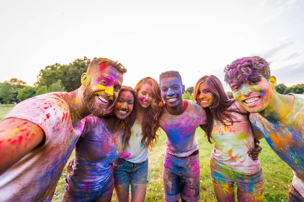 Holi ile oynarken mutlu arkadaş grubu bir parkta - Genç Yetişkin eğlenceli, eğlenceli ve genç nesil hakkındaki kavramları bir holi Festivali, eğleniyor renkler.