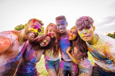 Holi ile oynarken mutlu arkadaş grubu bir parkta - Genç Yetişkin eğlenceli, eğlenceli ve genç nesil hakkındaki kavramları bir holi Festivali, eğleniyor renkler.