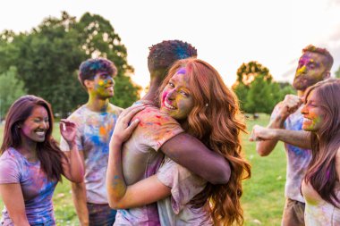 Holi ile oynarken mutlu arkadaş grubu bir parkta - Genç Yetişkin eğlenceli, eğlenceli ve genç nesil hakkındaki kavramları bir holi Festivali, eğleniyor renkler.