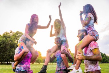 Holi ile oynarken mutlu arkadaş grubu bir parkta - Genç Yetişkin eğlenceli, eğlenceli ve genç nesil hakkındaki kavramları bir holi Festivali, eğleniyor renkler.