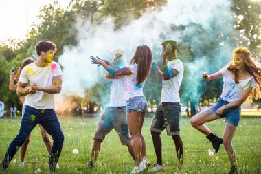 Holi ile oynarken mutlu arkadaş grubu bir parkta - Genç Yetişkin eğlenceli, eğlenceli ve genç nesil hakkındaki kavramları bir holi Festivali, eğleniyor renkler.