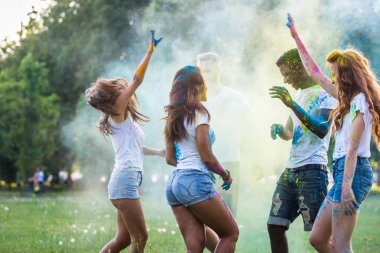 Holi ile oynarken mutlu arkadaş grubu bir parkta - Genç Yetişkin eğlenceli, eğlenceli ve genç nesil hakkındaki kavramları bir holi Festivali, eğleniyor renkler.