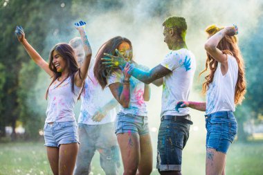 Holi ile oynarken mutlu arkadaş grubu bir parkta - Genç Yetişkin eğlenceli, eğlenceli ve genç nesil hakkındaki kavramları bir holi Festivali, eğleniyor renkler.