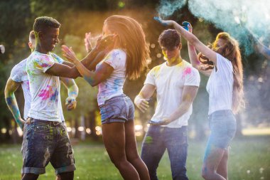 Holi ile oynarken mutlu arkadaş grubu bir parkta - Genç Yetişkin eğlenceli, eğlenceli ve genç nesil hakkındaki kavramları bir holi Festivali, eğleniyor renkler.