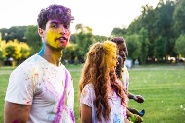 Holi ile oynarken mutlu arkadaş grubu bir parkta - Genç Yetişkin eğlenceli, eğlenceli ve genç nesil hakkındaki kavramları bir holi Festivali, eğleniyor renkler.