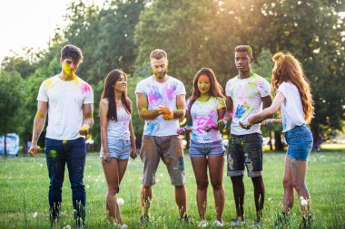 Holi ile oynarken mutlu arkadaş grubu bir parkta - Genç Yetişkin eğlenceli, eğlenceli ve genç nesil hakkındaki kavramları bir holi Festivali, eğleniyor renkler.