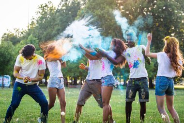 Holi ile oynarken mutlu arkadaş grubu bir parkta - Genç Yetişkin eğlenceli, eğlenceli ve genç nesil hakkındaki kavramları bir holi Festivali, eğleniyor renkler.