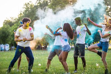 Holi ile oynarken mutlu arkadaş grubu bir parkta - Genç Yetişkin eğlenceli, eğlenceli ve genç nesil hakkındaki kavramları bir holi Festivali, eğleniyor renkler.