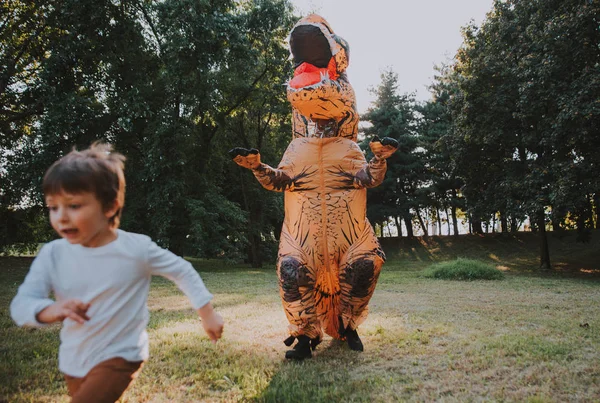 Vader Zoon Spelen Het Park Met Een Dinosaurus Kostuum Plezier — Stockfoto