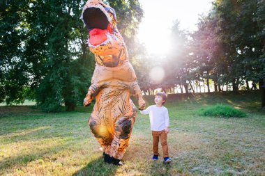 Baba ve oğul bir dinozor kostüm parkta oynarken açık aile ile eğleniyor