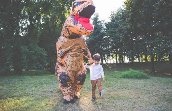 父と息子恐竜コスチュームで 公園で遊ぶ屋外の家族と一緒に楽しい時を過す — ストック写真