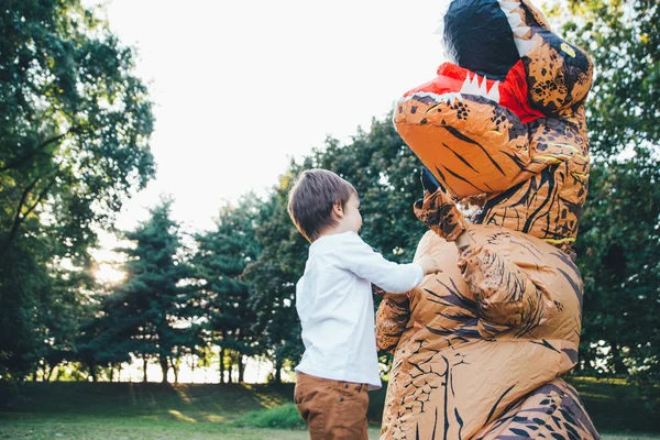 父と息子恐竜コスチュームで 公園で遊ぶ屋外の家族と一緒に楽しい時を過す — ストック写真