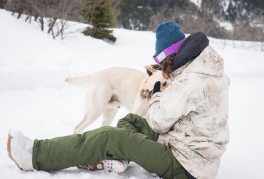 Sahibi ve köpeği karda - genç yetişkin adam onun sadık labrador ile eğleniyor oynarken