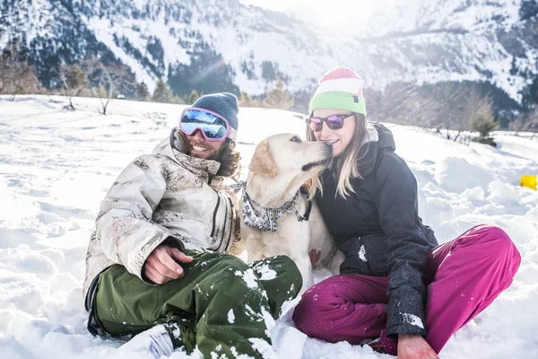 Ευτυχισμένο Ζευγάρι Παίζοντας Και Διασκεδάζοντας Πιστό Σκυλί Τους Στο Χιόνι — Φωτογραφία Αρχείου