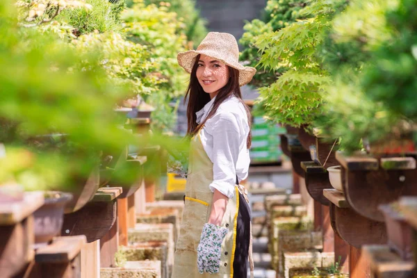 漂亮的女性园丁照顾植物在她的花卉商店 亚洲妇女在温室工作 — 图库照片