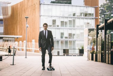 Genç yakışıklı adamla takım elbise bir longboard üzerinde - sürme kurumsal iş adamı portre, iş, hareketlilik ve yaşam tarzı ile ilgili kavramlar