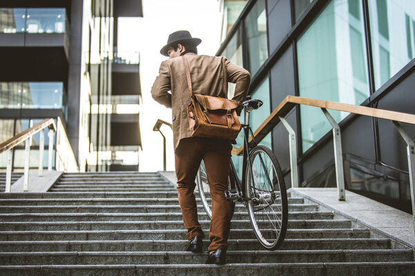 Молодой красивый мужчина в повседневной одежде за рулем велосипеда - портрет молодого студента, концепции бизнеса, мобильности и образа жизни
