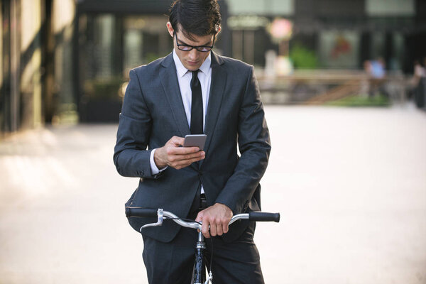 Young handsome man with business suit driving bycicle - Corporate businessman portrait, concepts about business, mobility and lifestyle