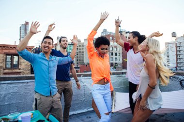 Group of friends spending time together on a rooftop in New york city, lifestyle concept with happy people clipart