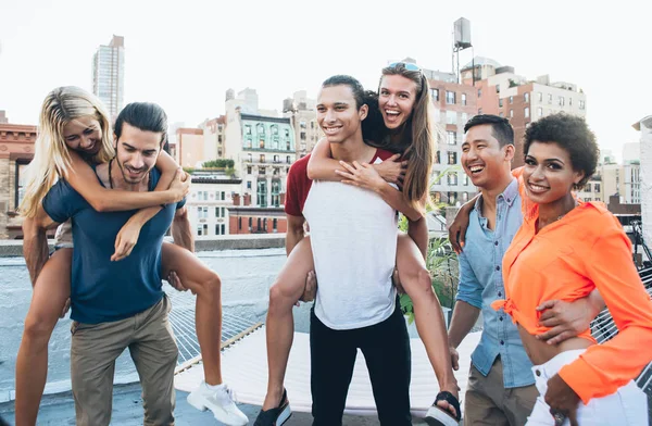 Group of friends spending time together on a rooftop in New york city, lifestyle concept with happy people