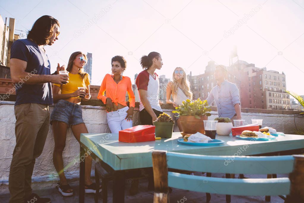 Group of friends apending time together on a rooftop in New york city, lifestyle concept with happy people