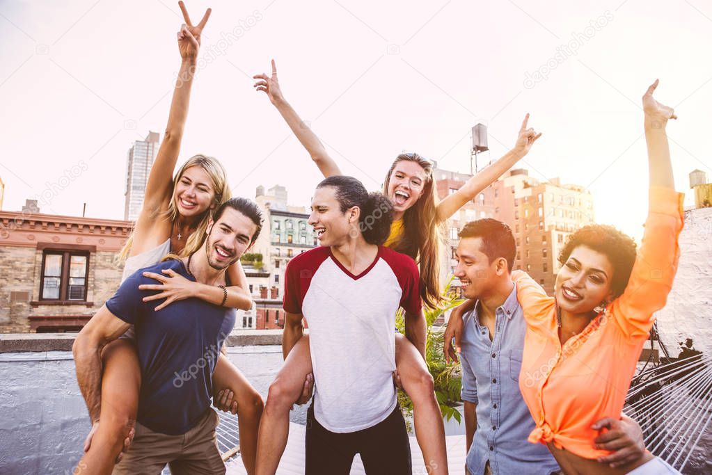 Group of friends spending time together on a rooftop in New york city, lifestyle concept with happy people