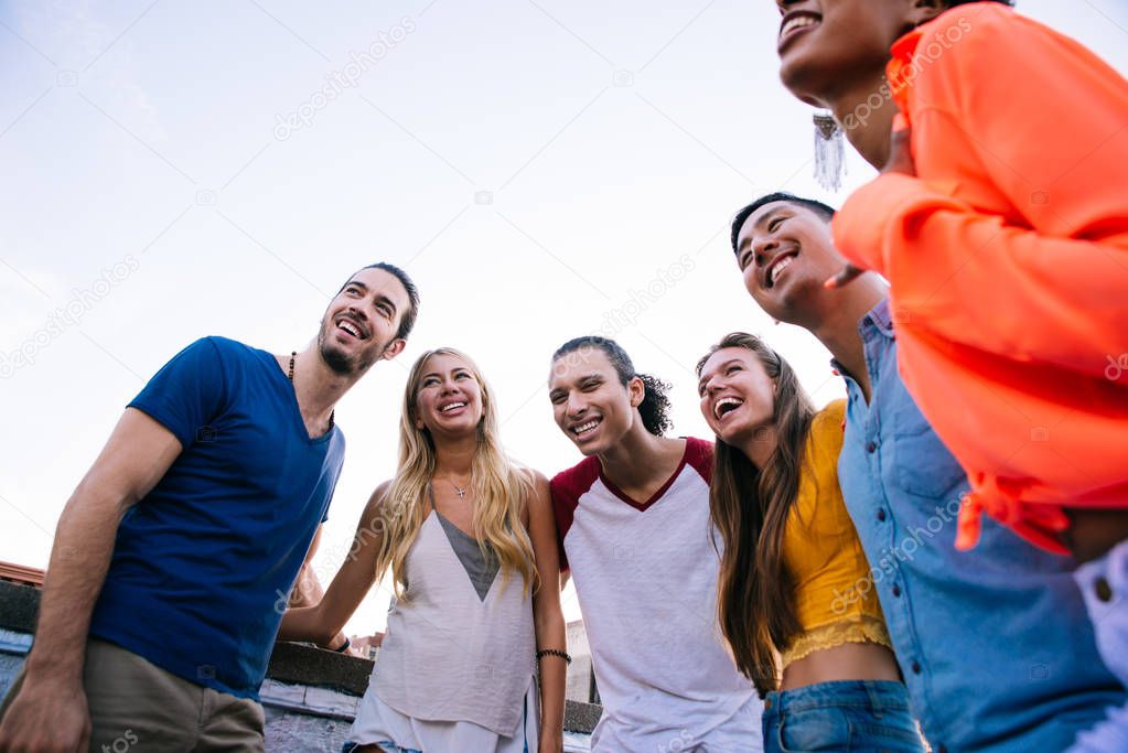 Group of friends spending time together on a rooftop in New york city, lifestyle concept with happy people