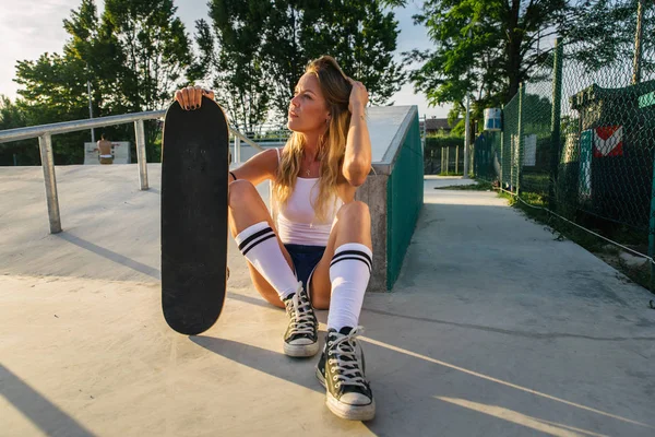 スタイリッシュな若い女性スケート屋外 かなり女性スケーターは彼女のスケートで遊んで — ストック写真