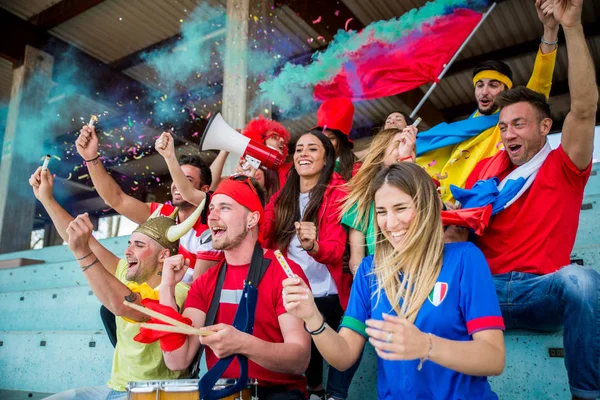 Football supporters at the stadium - Football fans having fun and looking at football match