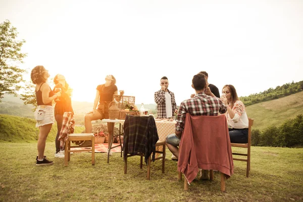 ピクニック アウトドア が楽しい時を過すと田舎に Ata Barbacue パーティーを焼きながら祝ってを持つ若い幸せな友人のグループ — ストック写真