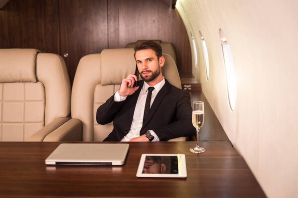 Businessman working while travelling on private jet - Portrait of business people taking a first class flight for work, concepts about business and mobility