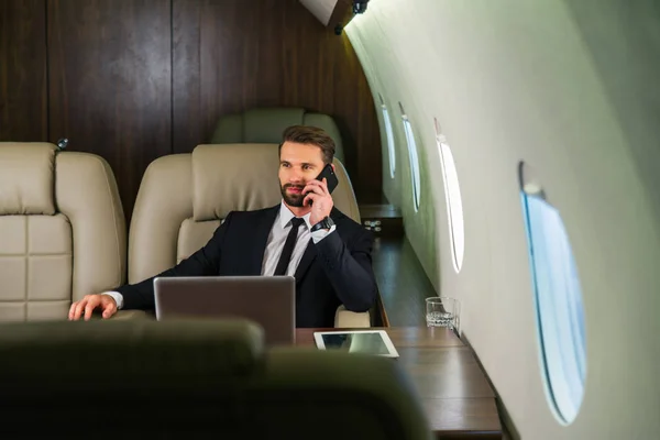 Businessman working while travelling on private jet - Portrait of business people taking a first class flight for work, concepts about business and mobility