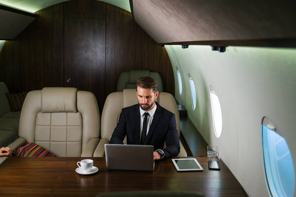Бизнесмен, работающий во время путешествия на частном самолете - Портрет деловых людей, летающих на работу первым классом, понятия о бизнесе и мобильности
