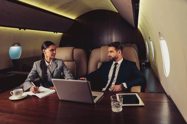 在乘坐私人飞机旅行时工作的商人和妇女 乘坐头等舱上班的商人的肖像 关于商业和行动的概念 — 图库照片
