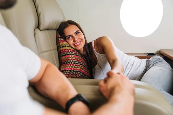 Happy couple travelling on a luxury private jet - Young adults travel on a first class flight, concepts about travel and lifestyle
