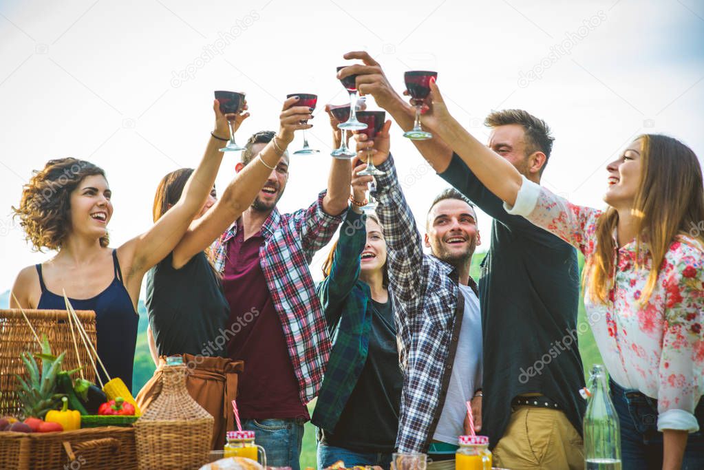 Group of friends making barbecue in the nature - Happy people having fun on a pic-nic in the countryside