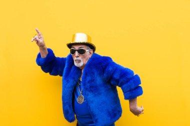 Komik ve savurgan komuta sizde renkli arka plan - genç yaşlı adam altmışlı yıllarda eğleniyor ve parti poz