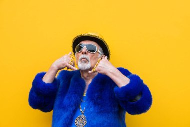 Komik ve savurgan komuta sizde renkli arka plan - genç yaşlı adam altmışlı yıllarda eğleniyor ve parti poz