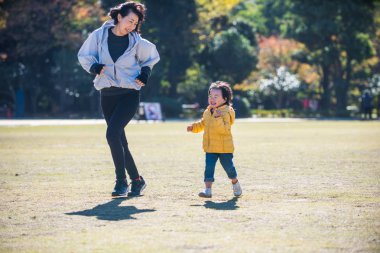 Mutlu ve neşeli Japon aile Tokyo'da bir parkta