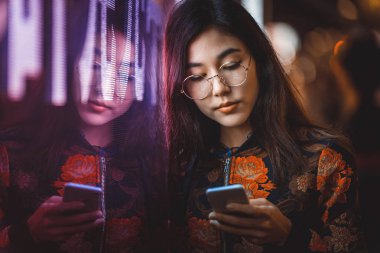 Açık havada, arka plan bulanık neon ışıkları ile poz güzel karışık ırk kadın