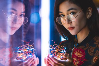 Açık havada, arka plan bulanık neon ışıkları ile poz güzel karışık ırk kadın