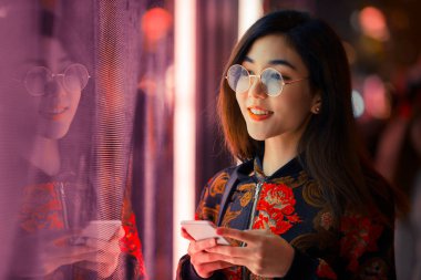 Açık havada, arka plan bulanık neon ışıkları ile poz güzel karışık ırk kadın