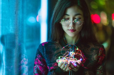 Açık havada, arka plan bulanık neon ışıkları ile poz güzel karışık ırk kadın