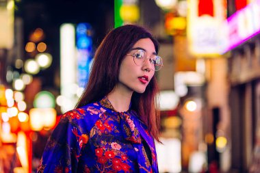 Açık havada, arka plan bulanık neon ışıkları ile poz güzel karışık ırk kadın